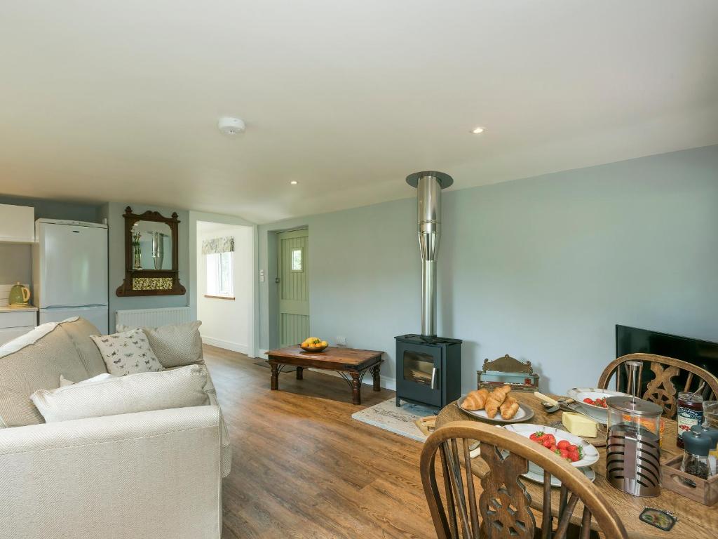uma sala de estar com um sofá e uma mesa em Barn Owl Lodge em Stoke Holy Cross