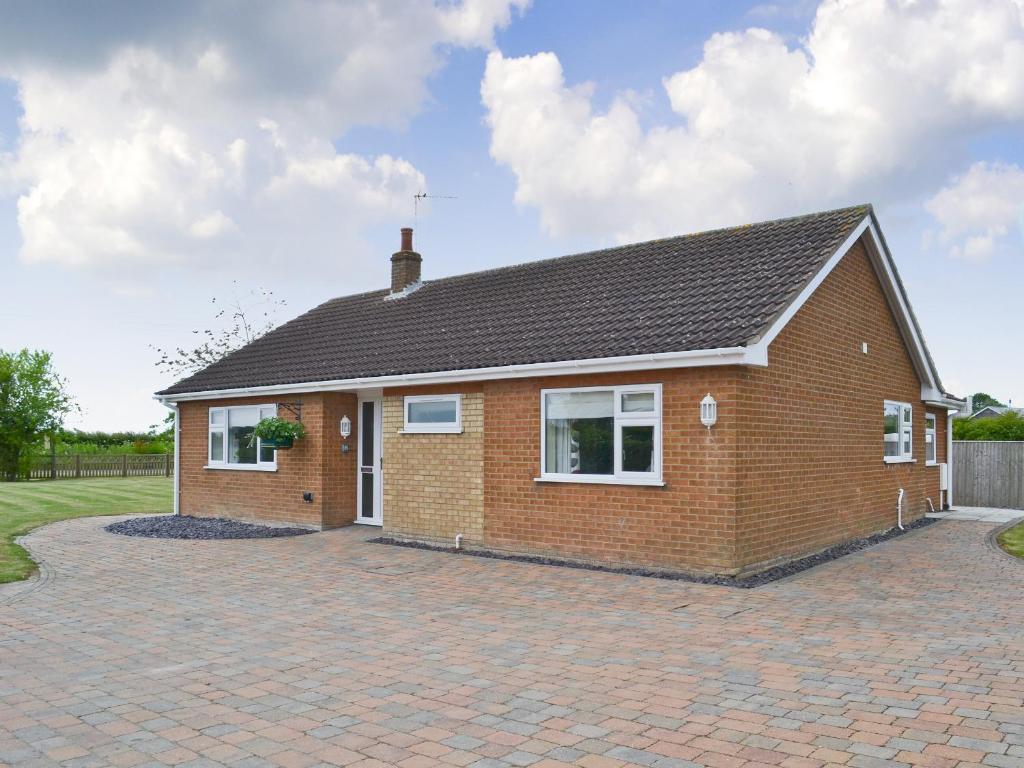 a brick house on a brick driveway at Henrys Bungalow in Anderby
