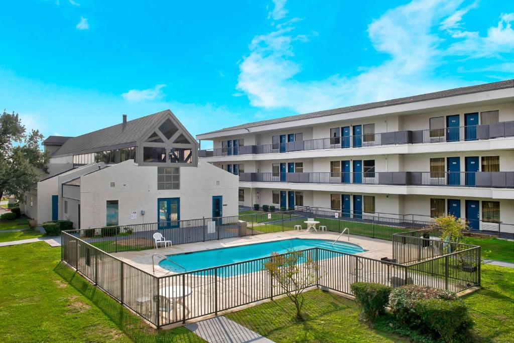 an apartment building with a swimming pool in front of it at Studio 6-San Antonio, TX - Airport in San Antonio