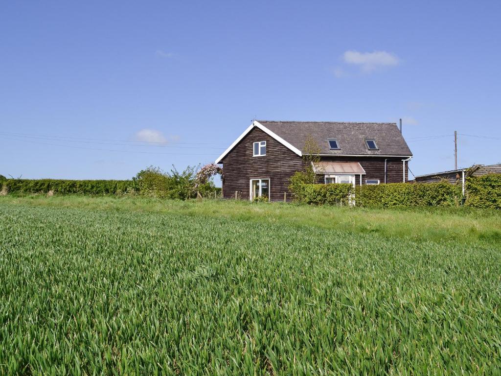 una casa en medio de un campo de hierba en Dale View Barn en Lusby