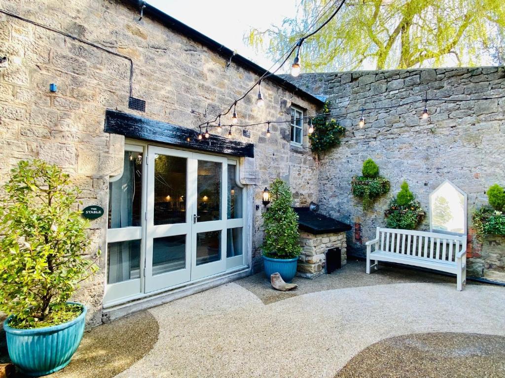 a patio with a bench and a brick building at The Stable - 28356 in Corbridge