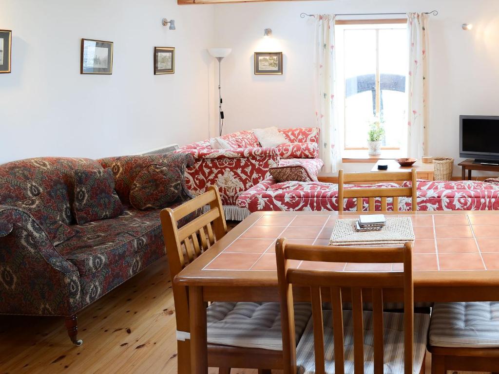 a living room with a couch and a table at Mill Cottage in John O Groats