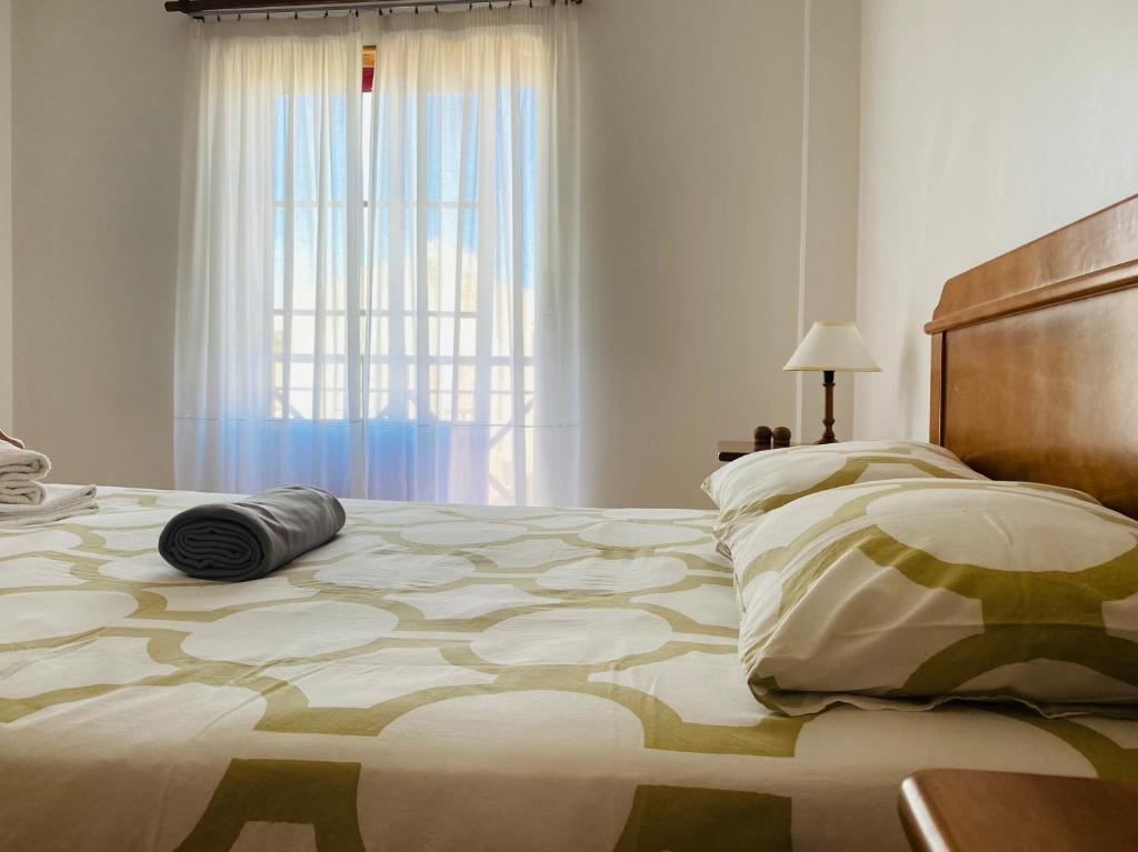 Un dormitorio con una cama grande y una ventana en SwordFish Beach Apartment en Peniche
