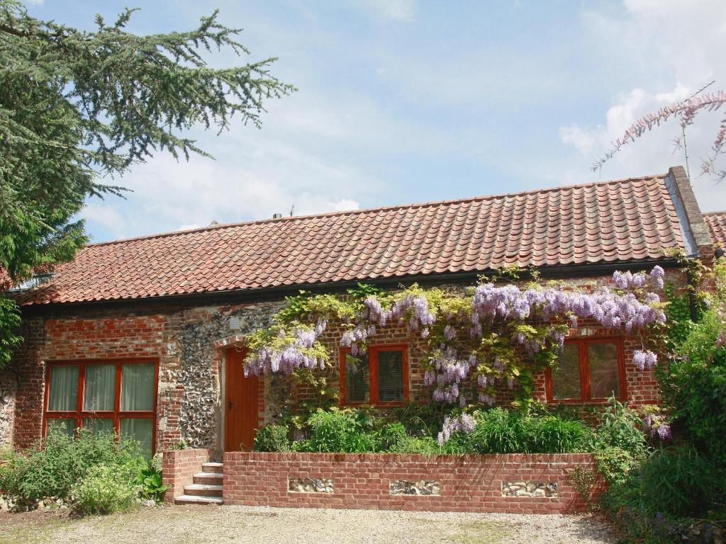 Drayton的住宿－農場穀倉街鄉村別墅，小屋的一侧有紫藤