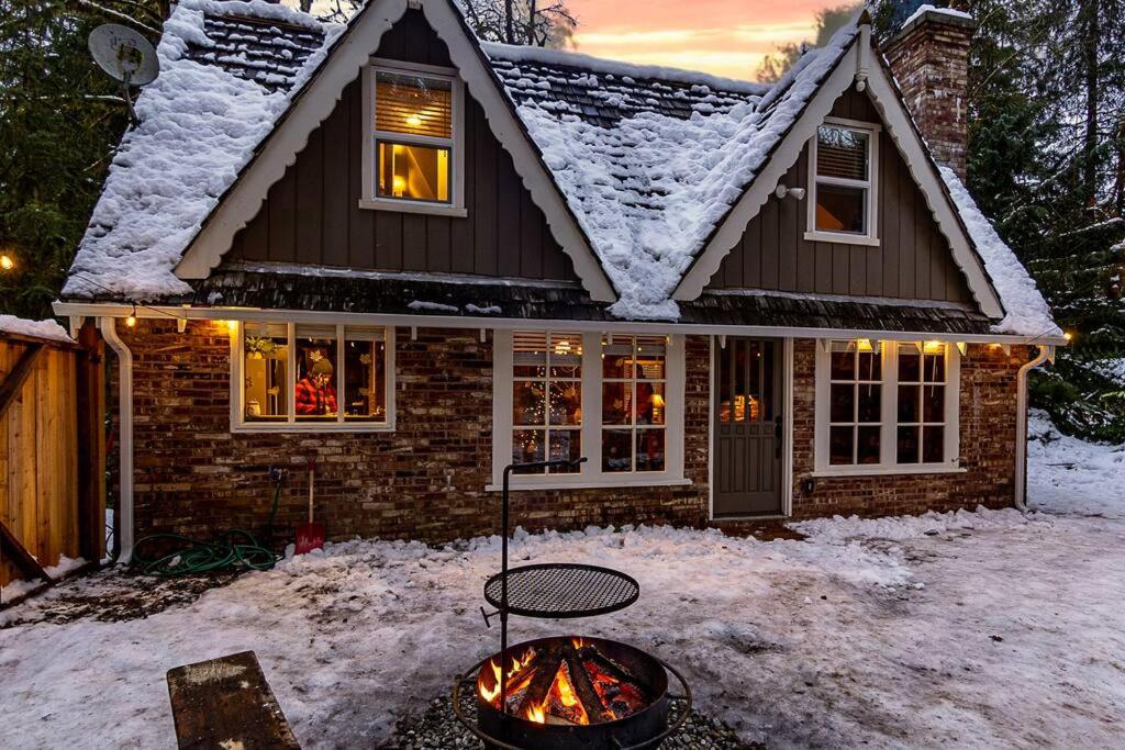 une maison avec un foyer extérieur dans la neige dans l'établissement Stilly River Haus - Hot-tub-Firepit-Fireplace, à Granite Falls