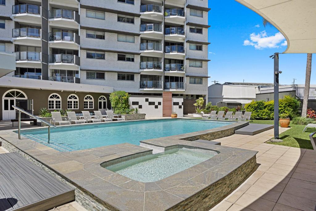 a swimming pool in front of a large building at Maroochy Sands Holiday Apartments in Maroochydore