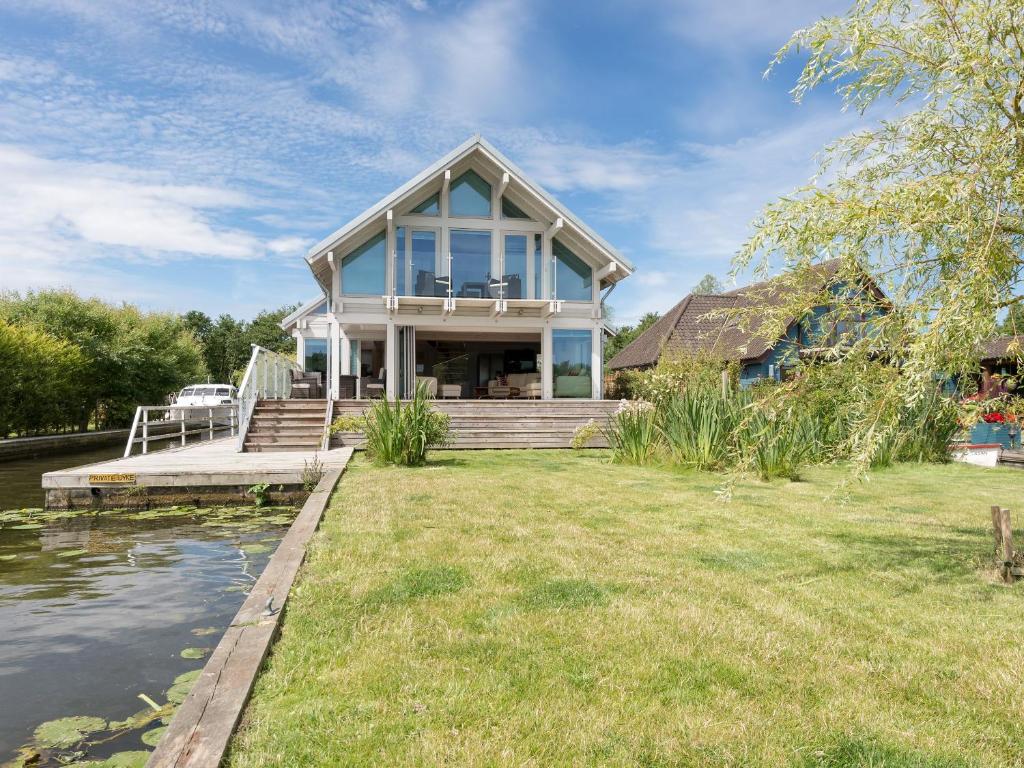 a house on the water with a dock at Silver Dawn in Horning
