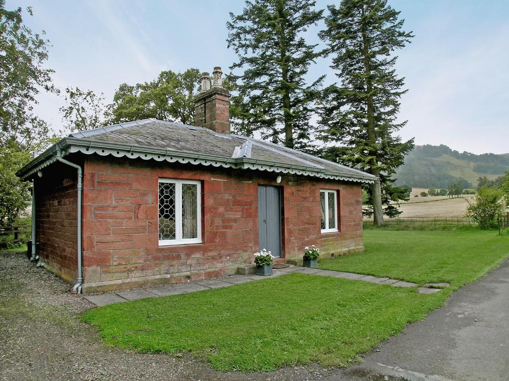 a small brick house with a chimney on top at Glenearn Lodge Cottage in Bridge of Earn