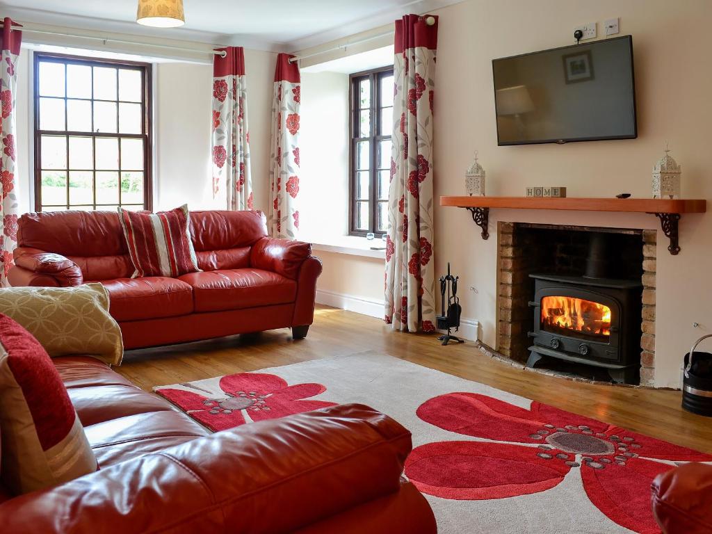 a living room with a couch and a fireplace at The Farmhouse - Ukc1339 in North Molton