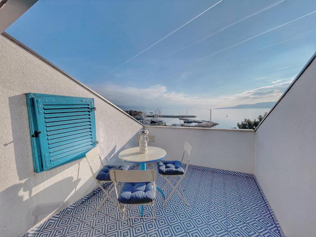 d'une table et de chaises sur un balcon avec vue sur l'océan. dans l'établissement Apartments Zoričić, à Novi Vinodolski