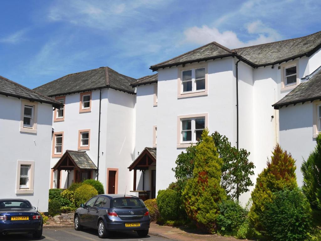 a row of white houses with cars parked in front at Elm Court 7 in Keswick