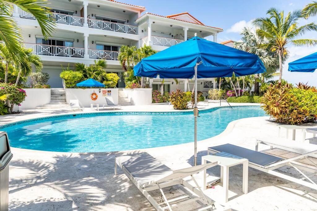 a pool with chairs and umbrellas in front of a hotel at Shore to Please - Large Studio Condo in Turtle Cove