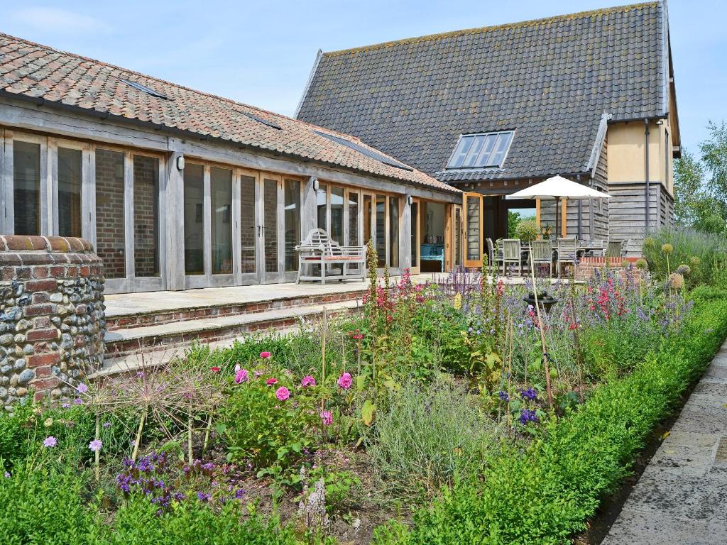 a garden in front of a house with flowers at Low Farm Barn in Laxfield