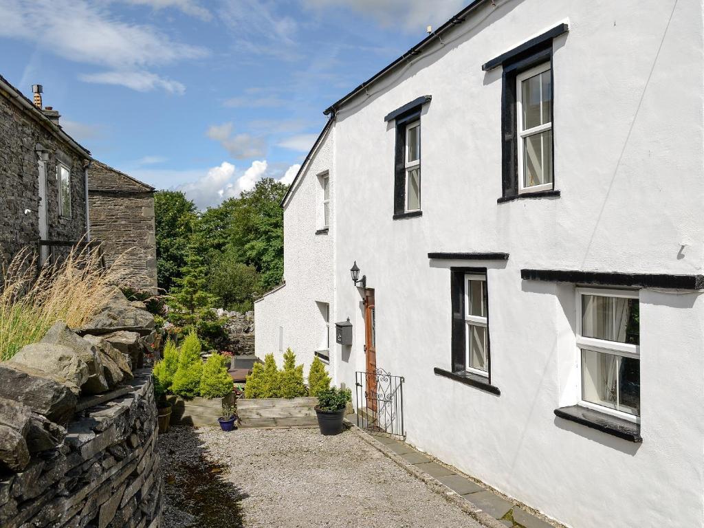 a white house with a stone wall at Riverside Cottage in Horton in Ribblesdale