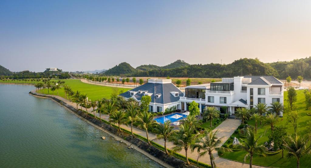 an aerial view of a house next to a river at The Five Villas & Resort Ninh Binh in Tam Ðiệp