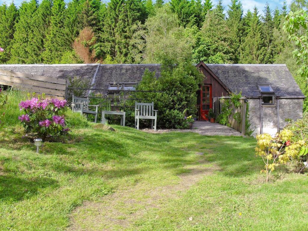 ダンケルドにあるOsprey Cottageの小屋とベンチと花の庭園