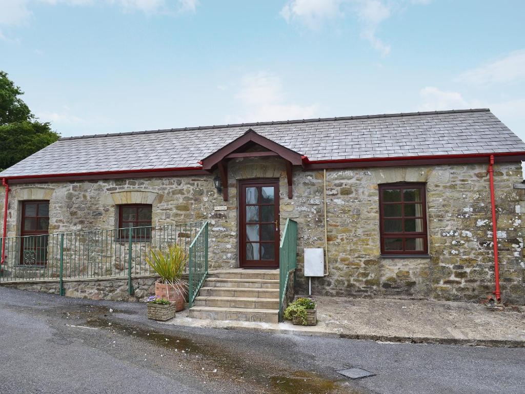 une ancienne maison en pierre avec un escalier en face de celle-ci. dans l'établissement The Cottage - Osd, à Penbryn