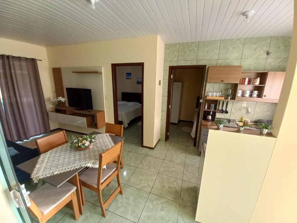 uma cozinha e uma sala de estar com mesa e cadeiras em Casa Bromélia 2 em Pomerode