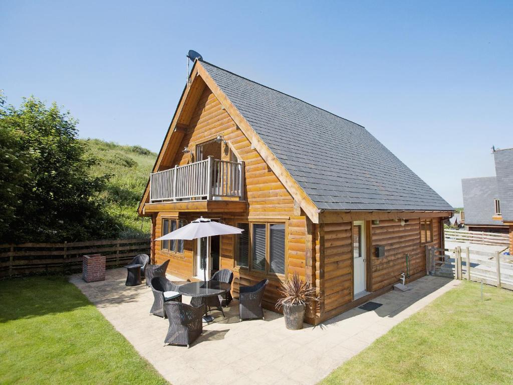 a cabin with a table and chairs and an umbrella at Hillview in Little Petherick