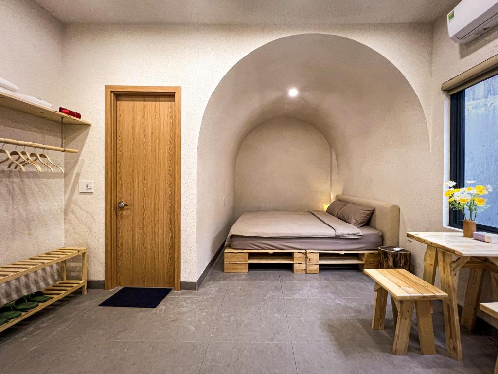 1 dormitorio con 1 cama en una habitación con forma de arco en Lều Vịt Homestay Hải Phòng, en Hạ Lý