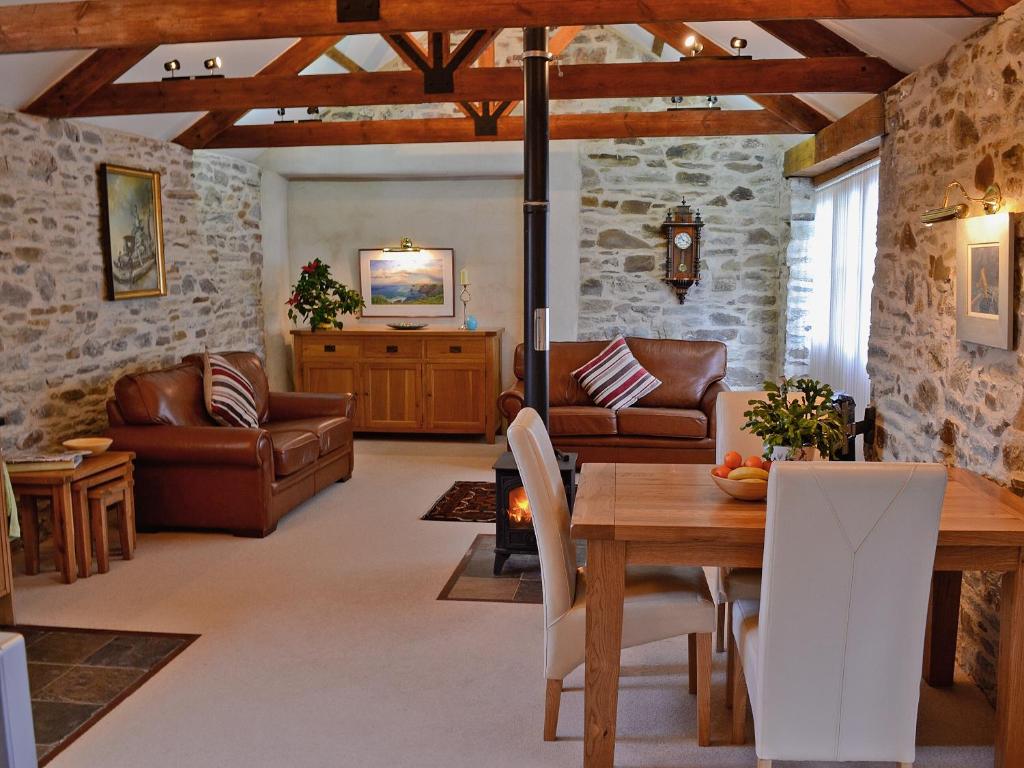 a living room with a wooden table and chairs at Penno Cottage - 24440 in Bodmin