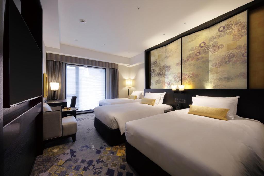 a hotel room with two beds and a television at THE HOTEL SANRAKU KANAZAWA 21th December 2022 OPEN in Kanazawa