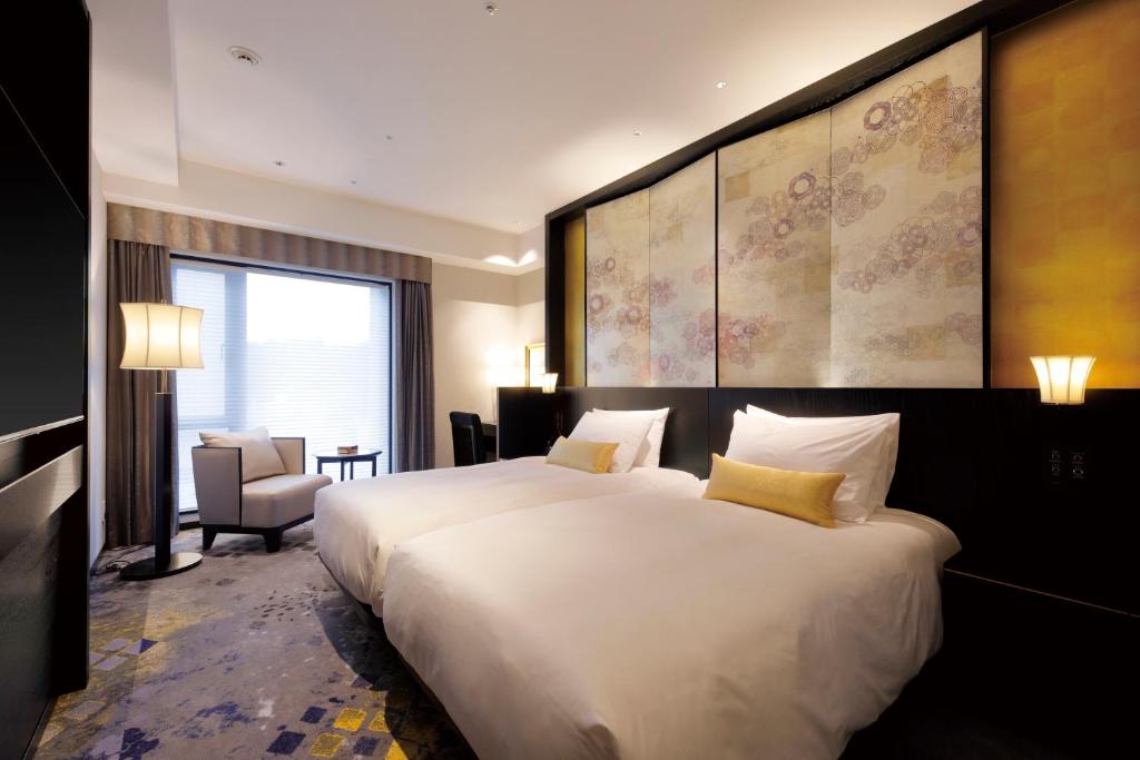 a hotel room with two large white beds in it at THE HOTEL SANRAKU KANAZAWA 21th December 2022 OPEN in Kanazawa