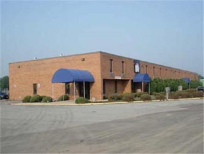 a large brick building with blue awnings in a parking lot at State Line Inn in Hagerstown