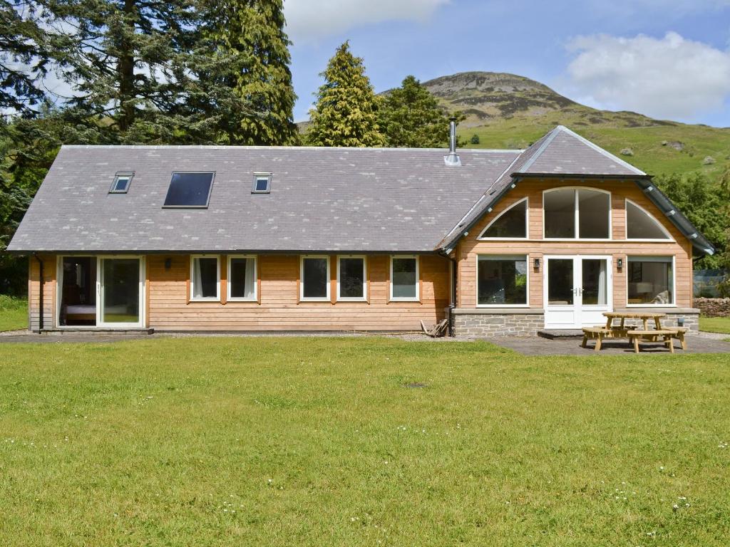 a house with a picnic table in a yard at Oak Lodge in Saint Fillans