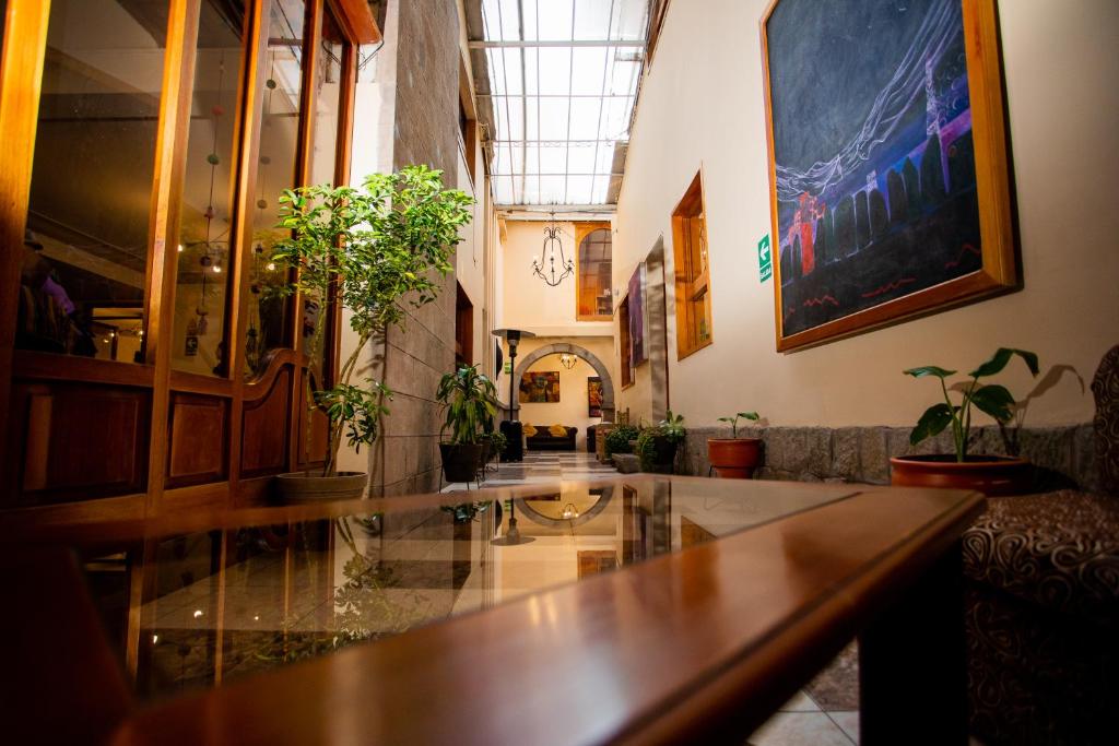 una hall con tavolo e piante in vaso di Centenario Inn a Cuzco