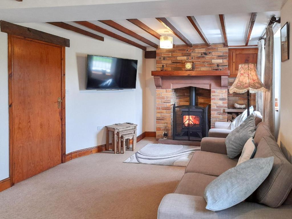 a living room with a couch and a fireplace at Greenrigg Cottage in Caldbeck