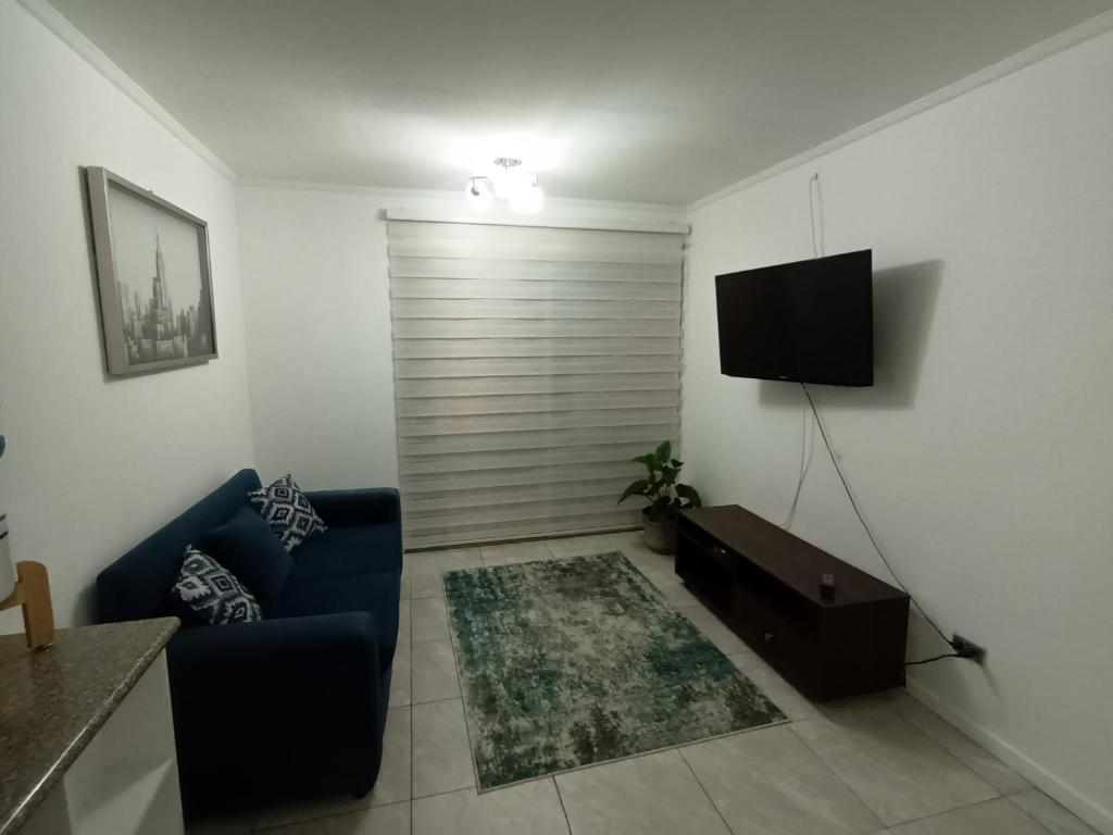 a living room with a blue couch and a television at Departamento entero 2 dormitorios en Mejillones 42 in Mejillones