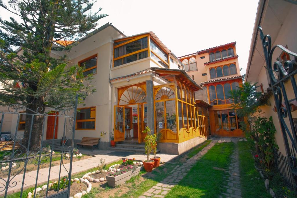 uma casa com portas amarelas e um quintal em Centenario Inn em Cusco