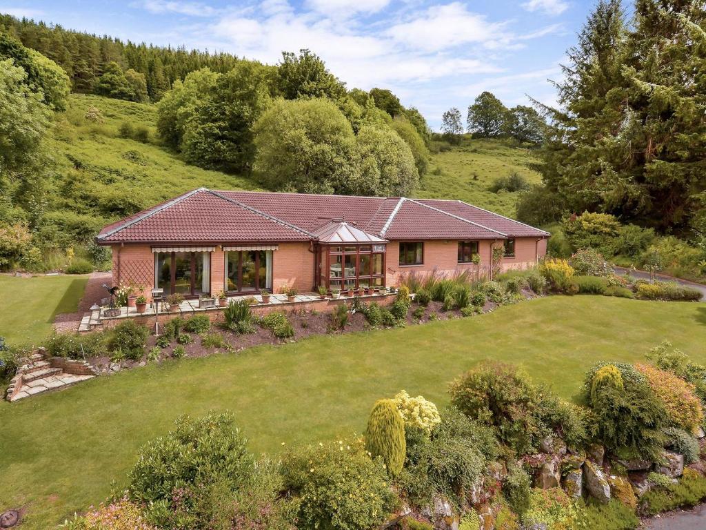 una casa su una collina con un cortile di Ard Taigh a Stron-fearnan