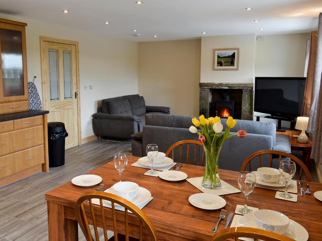 uma sala de estar com uma mesa com cadeiras e um sofá em Booth Farm Cottage em Buxton