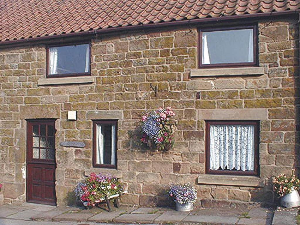 a stone house with flowers in front of it at Seran Gypsy in Hartoft End