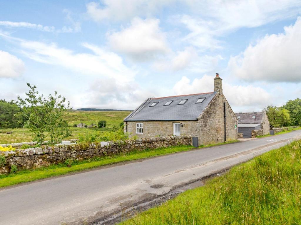 an old stone house on the side of a road at Kerseycleugh Bridge Cottage in Kielder