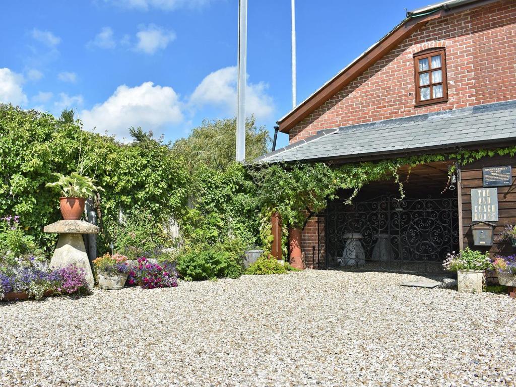 een binnenplaats van een bakstenen gebouw met bloemen en planten bij Railway Cottage in Wool