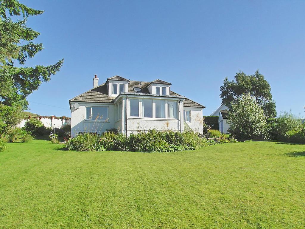 a large house on a grassy hill with a yard at Seabank Cottage in Clachan