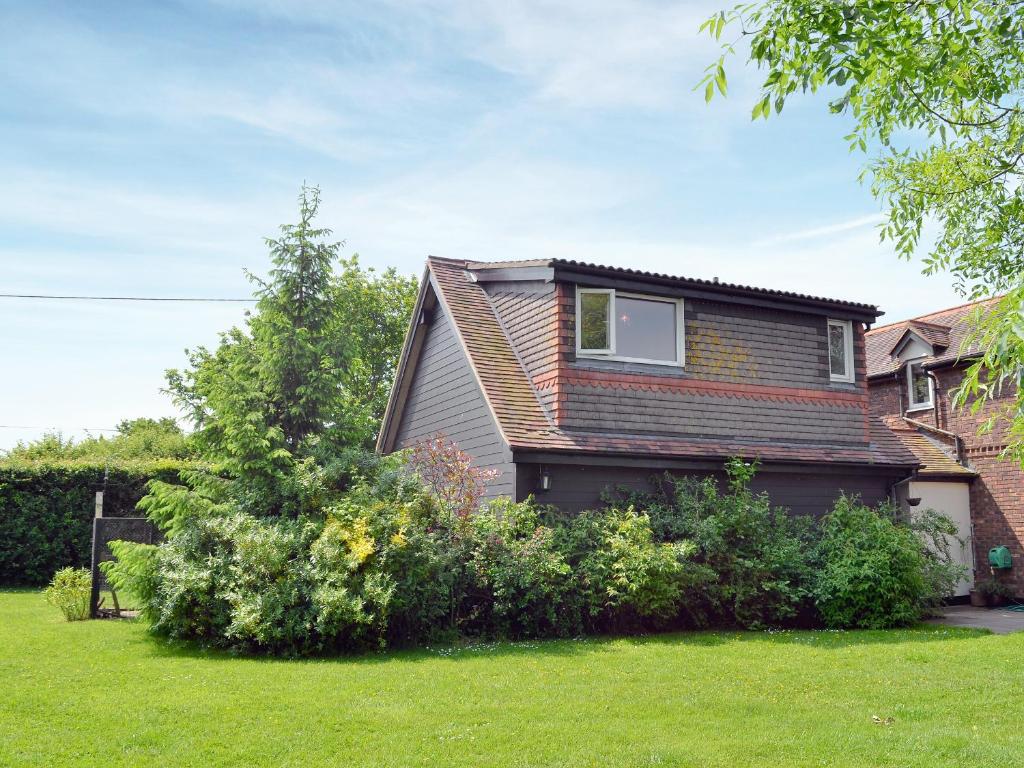 una casa con algunos arbustos en el patio en Hillcroft en Cold Norton