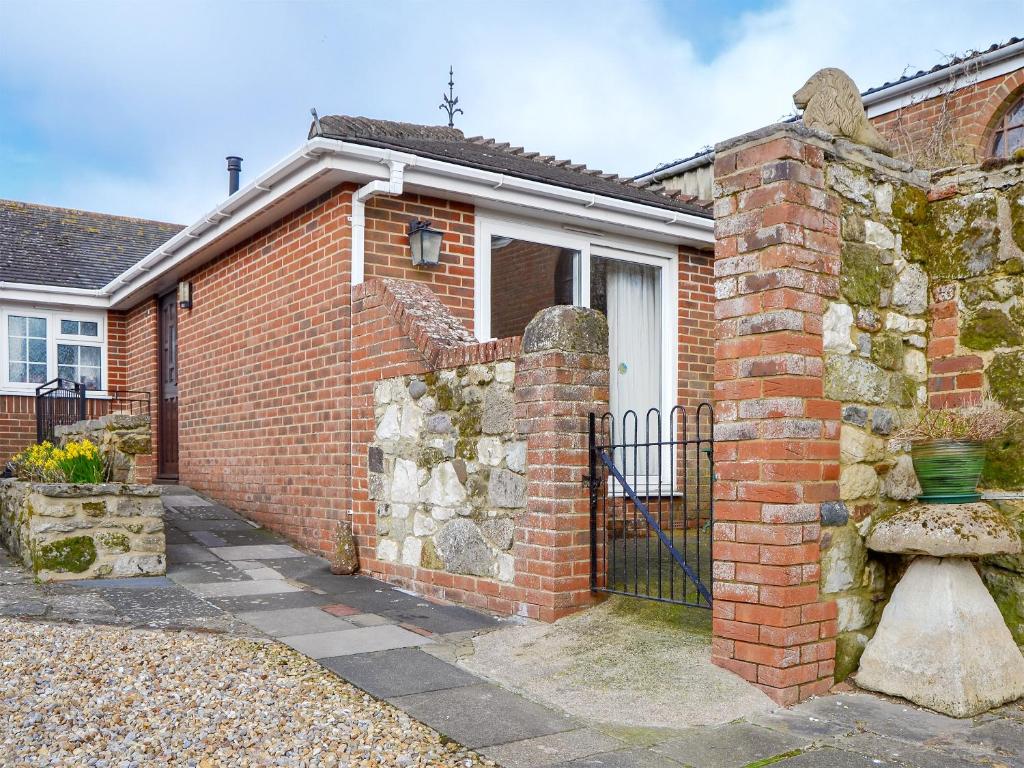 a brick house with a gate in front of it at The Annexe in Newchurch