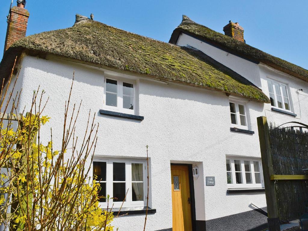 Folly Cottage في Kentisbeare: منزل أبيض بسقف من العشب