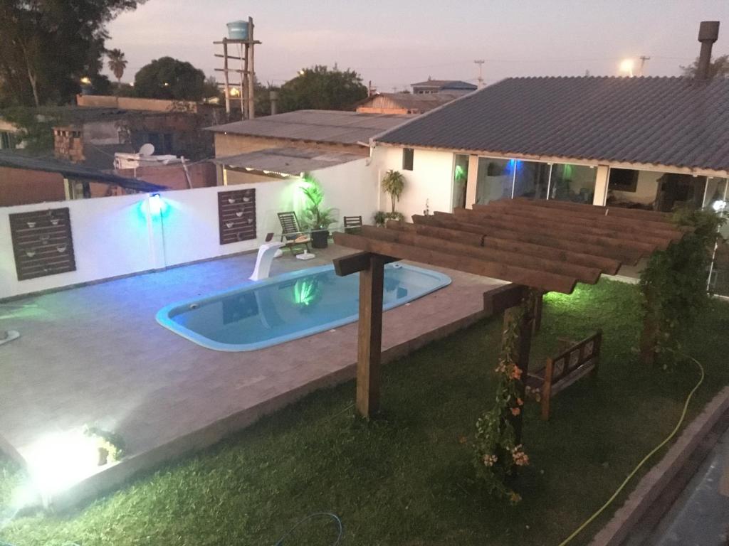 een huis met een zwembad en een houten terras bij Quitinete com piscina em Balneário Pinhal in Pinhal