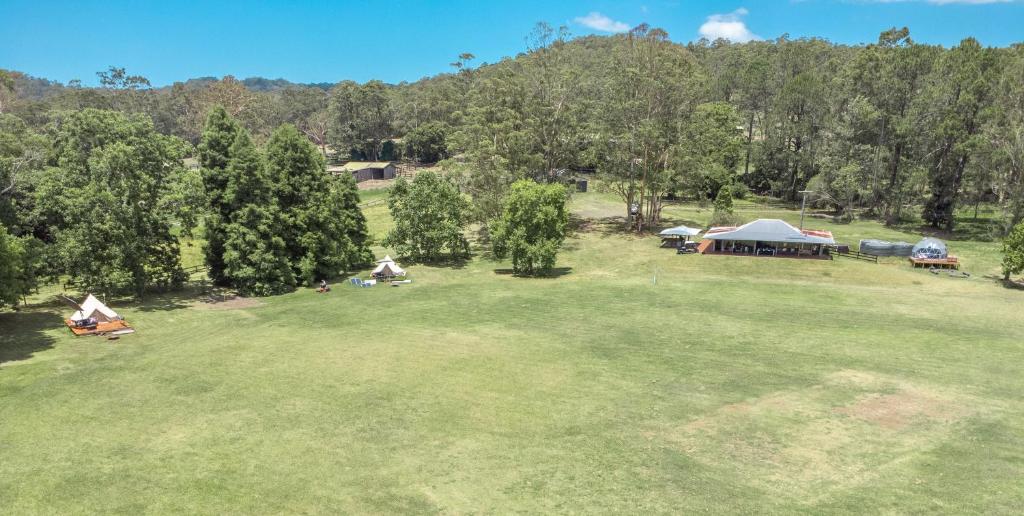 an aerial view of a park with tents and trees at Unwind Escapes Cabins & Glamping in Dooralong
