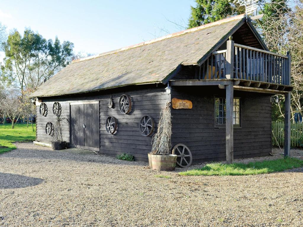 an old wooden barn with a deck on it at Byre Cottage - 29410 in Elmsted