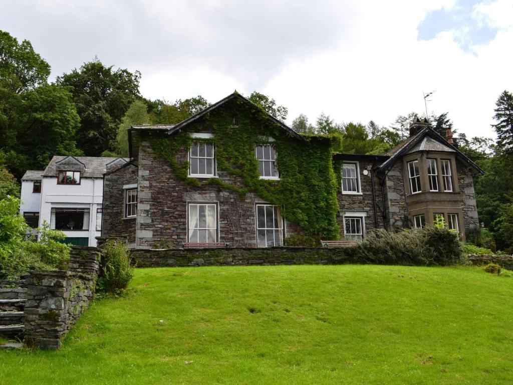 a large stone house with ivy growing on it at Langdale Crag in Grasmere
