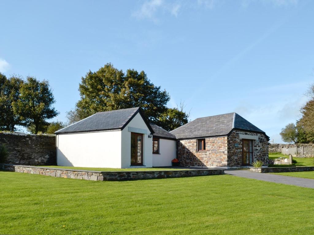 a detached house with a lawn in front of it at Kettles On - Tkc in Tresmeer