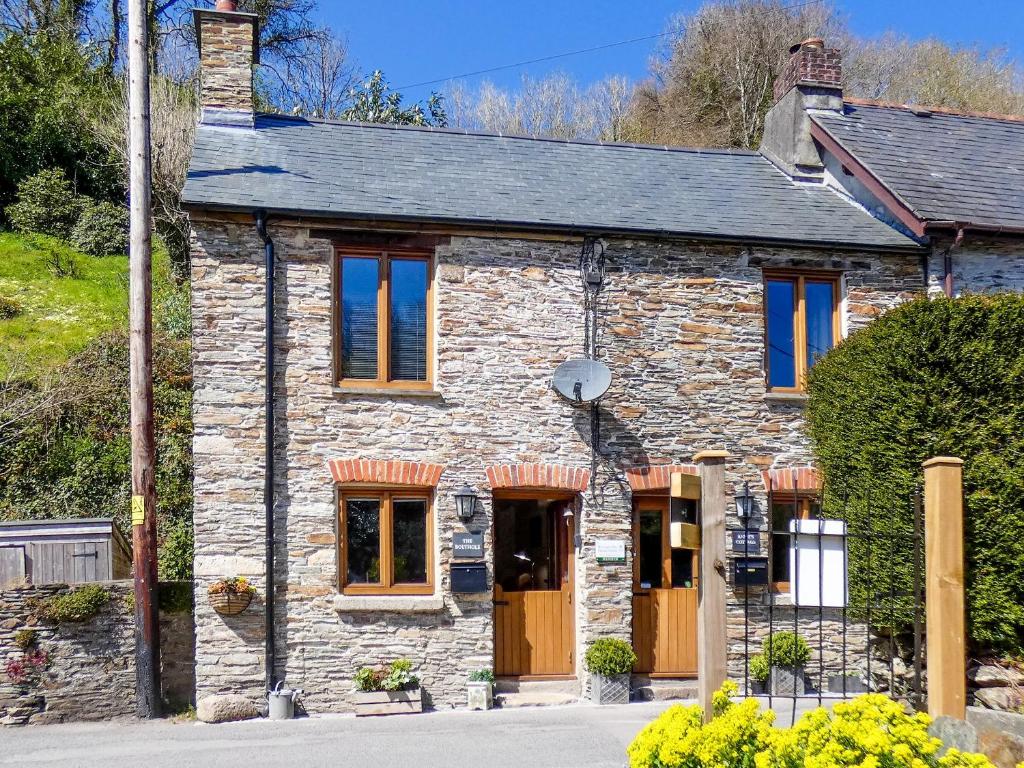 a stone house with wooden doors and windows at The Bolthole - 28188 in Yelverton