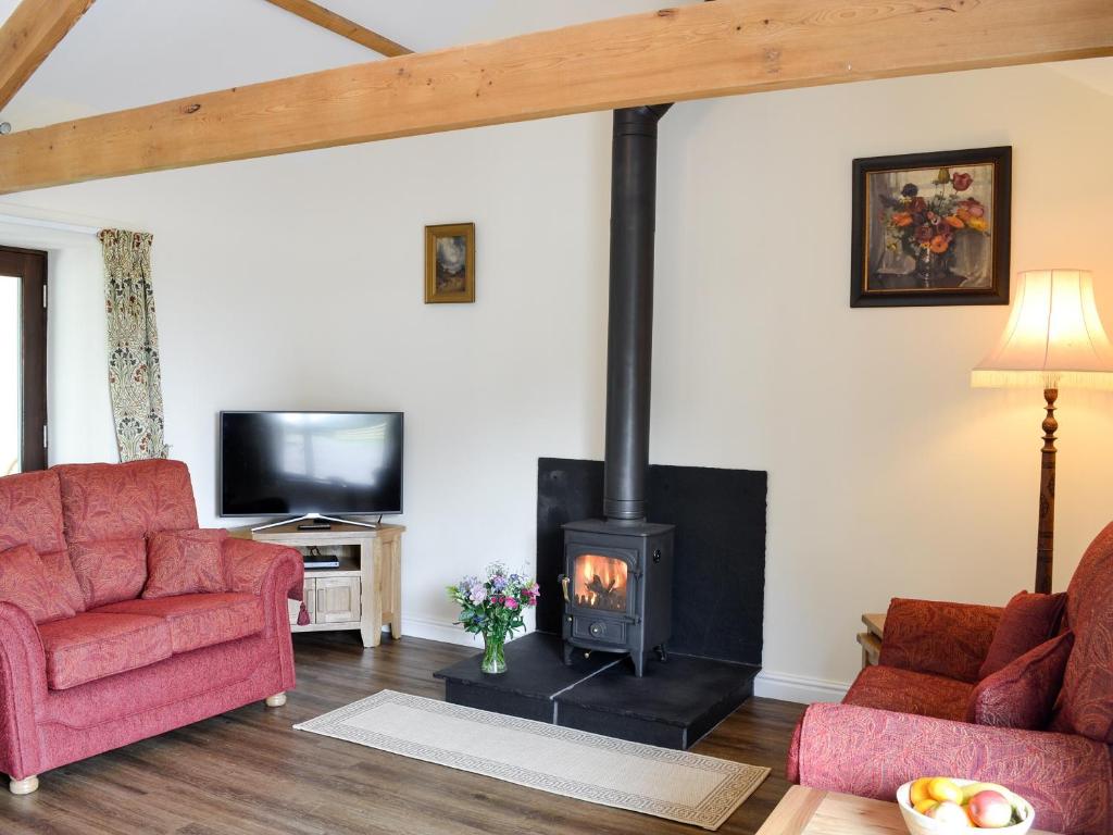 a living room with a wood stove at Brunos Bothy in Wigton