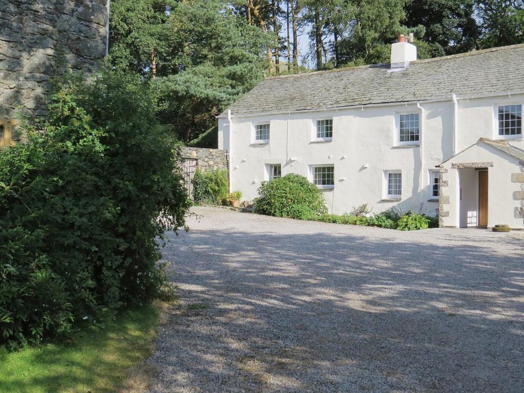 a white house with a driveway in front of it at Garries Cottage in Bassenthwaite